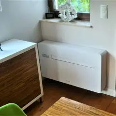 Nowoczesny klimatyzator bez jednostki zewnętrznej, dyskretnie wkomponowany w eleganckie wnętrze.