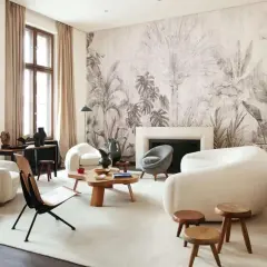 Nowoczesny salon z sofami w kształcie chmur i egzotyczna tapeta z motywem roślinnym tworzą przytulną atmosferę.