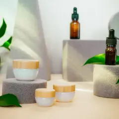 Kremy i serum w szklanych buteleczkach, otoczone zielonymi liśćmi. Wiele osób szuka dobrych **cerave opinie** przed zakupem.