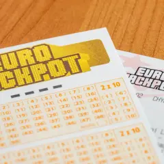 Kupony Eurojackpot na drewnianym tle. Zastanawiasz się, dlaczego Polska dołączyła do Eurojackpot tak późno w porównaniu do sąsiadów?