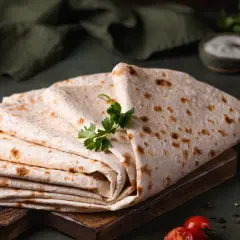 Stos cienkiego, puszystego lawaszu, co to jest? Idealny do wrapów, z pomidorkami, papryczką i ziołami.