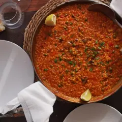 Paella mixta, un clásico que no puede faltar si te preguntas qué comer en Cabo de Gata. Servida en una paellera, con limón y pan.