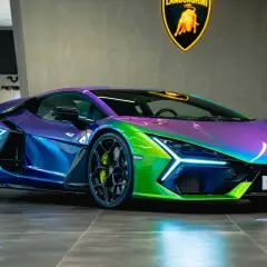 Lamborghini Aventador con vernice cangiante, un capolavoro glitterato che riflette luci viola, blu e verdi.