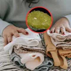 Manos doblando ropa limpia, con una piedra amarilla brillante que evoca el olor a mercaptano.
