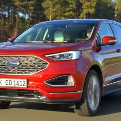 Czerwony Ford Edge na drodze, z widocznym grillem i tablicą rejestracyjną K ED 1412.