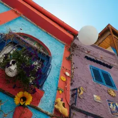 Coloratissimi edifici a Vietri sul Mare: cosa vedere? Finestre fiorite, decorazioni marine e un cielo azzurro.