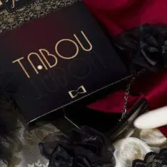 Eleganckie opakowanie "TABOU" z czarnymi piórami, koronkami i białym wibratorem. Idealne do odkrywania najlepszych sex gier.
