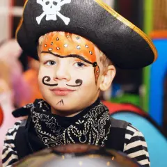 Kleiner Seeräuber mit Piratenhut und einem tollen **Piratenbart schminken**-Gesicht.