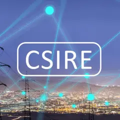 Sieć energetyczna miasta nocą, z liniami przesyłowymi i neonowym napisem "CSIRE".