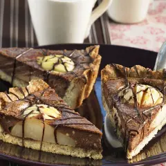 Drei Stücke saftiger Birnen Schoko Kuchen auf einem Teller, verziert mit Schokoladenglasur und Birnenstücken.