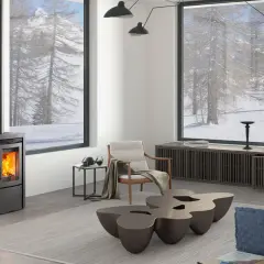 Estufa de pellets moderna en un salón acogedor con vistas nevadas. ¿Qué tipo de estufa es mejor para crear este ambiente cálido?
