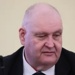 Jan Kowalski, syn Wacława Kowalskiego, w garniturze, z mikrofonem przed sobą.