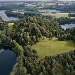Malownicze jeziora i lasy tworzą magiczne miejsca na Podlasiu. Widok z lotu ptaka na zielone wzgórza i spokojne wody.