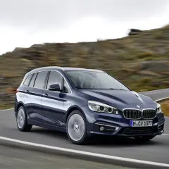 Un BMW Serie 2 Gran Tourer azul oscuro en una carretera sinuosa. A pesar de su diseño, algunos propietarios han reportado problemas.