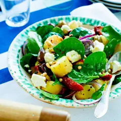 En härlig hemmagjord potatissallad med färsk spenat, fetaost, oliver och soltorkade tomater. Perfekt till sommarlunchen!