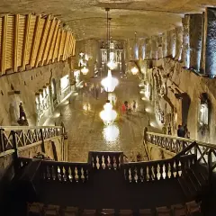 Wieliczka wycieczka: podziemna kaplica z kryształowymi żyrandolami i rzeźbami w soli. Widok z góry na schody i balustrady.