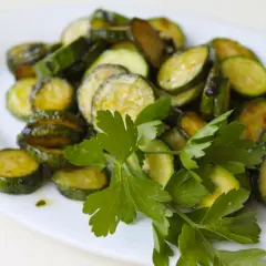 Fette di zucchine saltate in padella, condite con olio e prezzemolo fresco, un classico piatto di zucchine alla poverella.