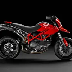Czerwony Ducati Hypermotard 796 z czarnymi felgami i wydechem, gotowy do jazdy po miejskich ulicach.