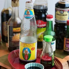 Flera flaskor sojasås, inklusive Kikkoman och Sakura Japansk Soja. Sojasås görs av fermenterade sojabönor, vete, salt och vatten.