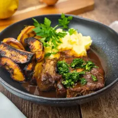 Ein Teller mit Ossobuco, dazu Kartoffelpüree und geröstete Kartoffelspalten. Dieses Ossobuco Rezept original italienisch ist ein Genuss!
