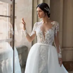 Elegancka panna młoda w sukni z koronki i tiulu, z ozdobną biżuterią we włosach. Inspiracja dla fryzur na ślub.