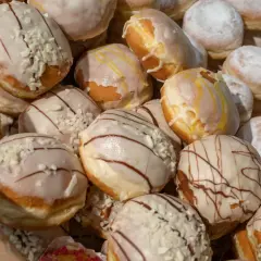 Pączki z lukrem i posypką, niektóre z polewą czekoladową. Czy paczki można mrozic? Tak, można je zamrozić, by cieszyć się nimi dłużej.