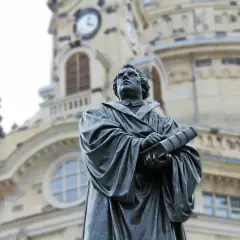Pomnik Marcina Lutra, symbol reformacji i luteranizmu, na tle zabytkowego kościoła.
