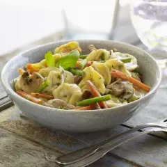 Tortellini con champiñones, zanahoria y espárragos en una cremosa salsa para pastel de verduras.