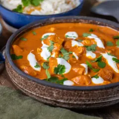 En krämig kyckling tikka masala med ris och en klick gräddfil.