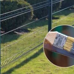 Pędzel z farbą do malowania siatki ogrodzeniowej. Odnawianie ogrodzenia.