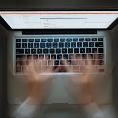Ręce szybko piszą na klawiaturze laptopa. Widać ekran z kodem. Szybkie pisanie to jak zaznacz wszystko skrót.