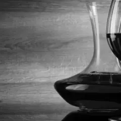 Caraffa e due calici di vino rosso, con un'atmosfera che evoca un buon cannellino di Frascati.