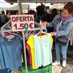En el mercadillo de Gandía, una mujer busca ofertas. Ropa a 1,50€ en un puesto.