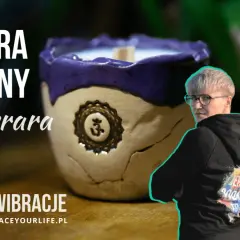 Ceramiczna świeca z symbolem Om i dwie kobiety w bluzach z kapturem.