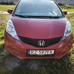 Czerwona Honda Jazz z tablicą RZ 597FK. Zastanawiasz się, jaki olej do Hondy Jazz 1.4 benzyna? Ten model zasługuje na najlepszy!