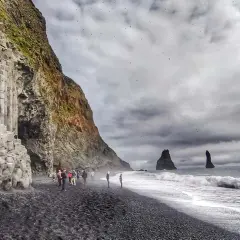 Słynna plaża Reynisfjara z bazaltowymi kolumnami i skalnymi formacjami w morzu.