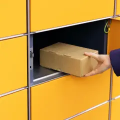 Ręka wkłada paczkę do żółtego paczkomatu. Co jeśli nie odbiorę paczki z paczkomatu? Zostanie odesłana.