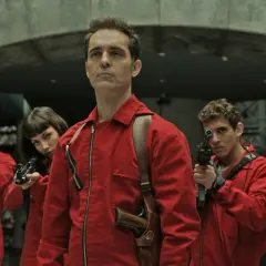 Das Team vom Haus des Geldes Berlin ist bereit. Fünf Personen in roten Overalls und Masken halten Waffen.