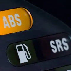 Pomarańczowy przycisk z napisem ABS i obok zielony z ikoną paliwa oraz przycisk SRS.