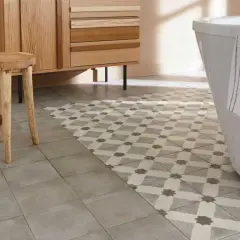 Un sol de salle de bain avec deux types de carrelage : un uni gris et un à motifs géométriques. Une idée pour peindre carrelage sol et moderniser une pièce.