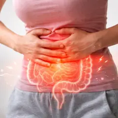 Dolore addominale e infiammazione intestinale, possibili colite sintomi. Mani che stringono l'addome con un'illustrazione luminosa dell'intestino.