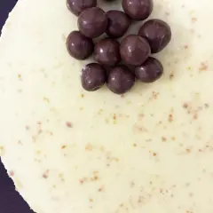 Deliciosa tarta de chocolate blanco, cubierta con crujientes bolitas de chocolate oscuro. ¡Un postre irresistible!