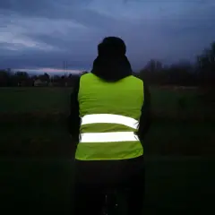 Person mit Warnweste Fahrrad im Dämmerlicht. Sichtbarkeit ist wichtig, auch wenn es nicht verboten ist.