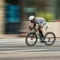 Dynamic racing photography captures a cyclist in motion, blurring the background to emphasize speed.