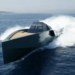Un elegante yacht, forse quello di Gianluca Vacchi, sfreccia sull'acqua blu, lasciando una scia bianca.