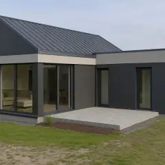 Nowoczesny dom parterowy bez garażu, z ciemnoszarą elewacją i dużymi przeszkleniami.