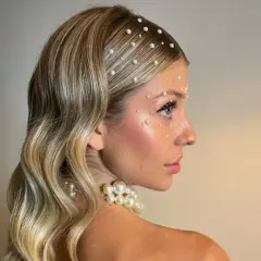 Peinados para salir de fiesta: melena rubia ondulada adornada con perlas en el cabello y rostro, look deslumbrante.
