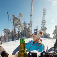 Trzech narciarzy cieszy się słońcem i piwem na stoku. Czy piwo może stać na mrozie? Tak, jeśli jest zimne!