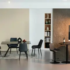 Salle à manger moderne avec chaises en cuir synthétique, table et coin bar.