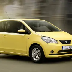Żółty Seat Mii pędzi ulicą, tworząc wrażenie ruchu.